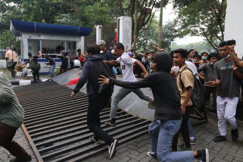 Massa merobohkan pagar gedung DPRD Kota Medan saat unjuk rasa menolak UU KPK hasil revisi dan RUU KUHP, di Medan, Sumatera Utara, Jumat (27/9/2019).