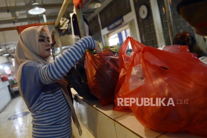 Pembeli memasukan barang belanjaan ke dalam kantong plastik di Pasar Senen, Jakarta, Rabu (3/7).