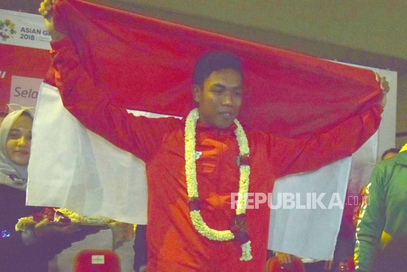 Atlet Athletik Indonesia  Lalu Muhammad Zohri  memegang bendera merah putih saat tiba  di Indonesia dari Finlandia di Bandara Internasional Soekarno Hatta, Tangerang,Banteng,Selasa (17/7).