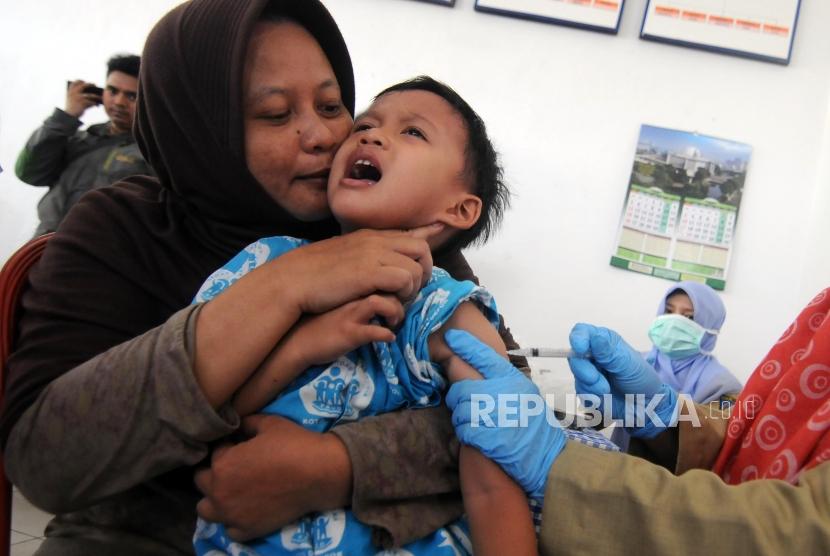 Imunisasi Massal Difteri. Seorang balita saat disuntik imunisasi Difteri di Posyandu Mawar, Pancoran Mas, Kota Depok, Jawa Barat, Senin (11/12).