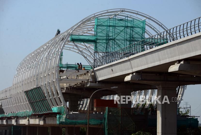 Sejumlah pekerja menyelesaikan pembangunan stasiun Kereta Light Rail Transit (LRT) di Jakarta, Jumat (4/1).