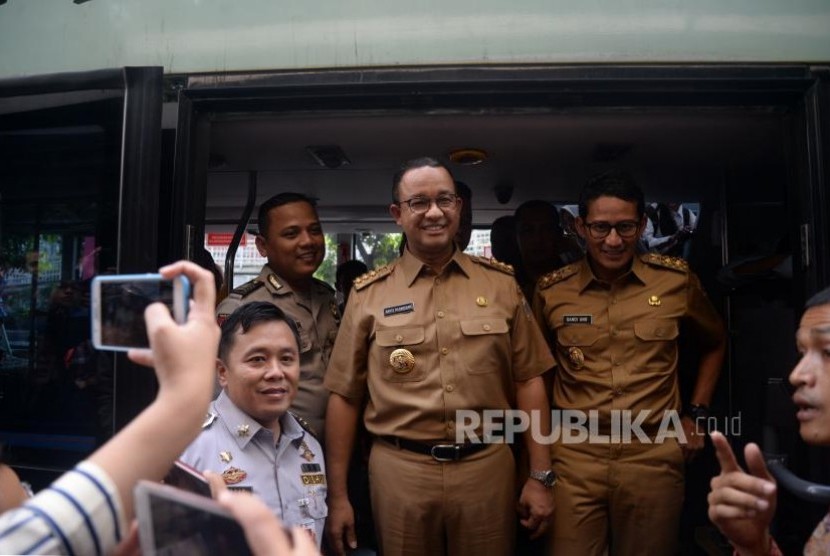 Gubernur DKI Jakarta Anies Baswedan dan Wakil Gubernur Sandiaga Uno menaiki bus City Tour di Halte Dukuh Atas, Jakarta, Selasa (17/10).