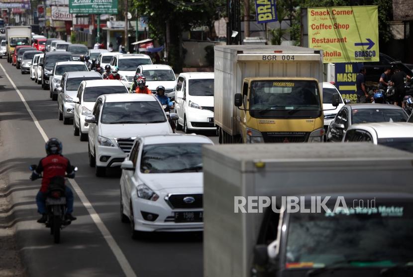 Antrean kendaraan saat penerapan satu arah (One way) di ruas Jalan Raya Puncak, Bogor, Jawa Barat, Sabtu (23/12).