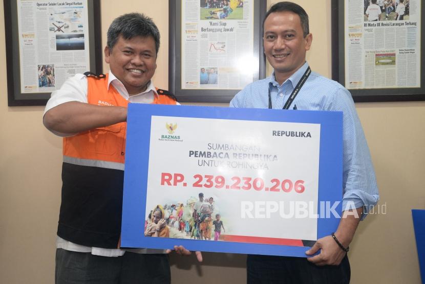 Dirut Republika Media Mandiri Agoosh Yoosran menyerahkan sumbangan pembaca Republika untuk Rohingya kepada Deputy BAZNAS M. Arifin Purwakananta (kiri) di Kantor Republika, Jakarta, Jumat (20/4).