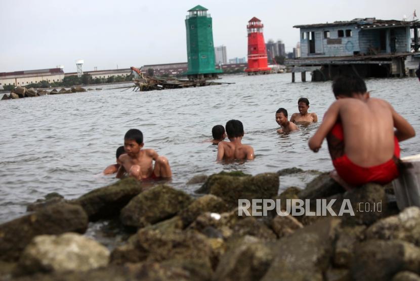 Anak-anak bermain di pesisir laut di Kawasan Muara Baru, Jakarta, Kamis (28/12).