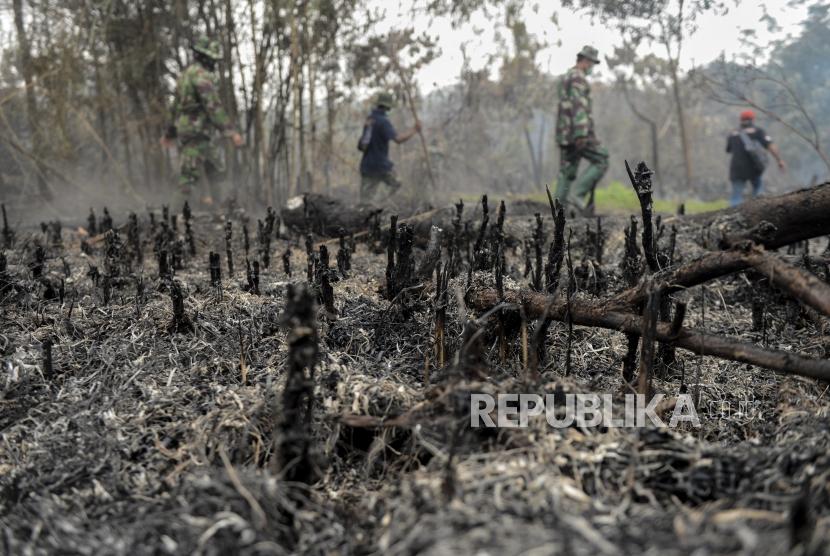 Sejumlah anggota TNI Kodim 0301/Pekanbaru melintas di dekat lahan gambut yang telah terbakar  (ilustrasi)