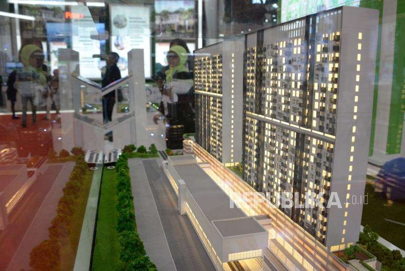 Penjaga stan menjelaskan tentang harga rumah dan fasilitasnya kepada calon konsumen saat pameran perumahan di Jakarta, Rabu (26/9).