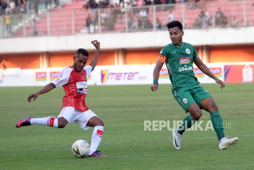 PSS Ditahan Imbang Persipura. Pemain PSS Ikhwan (kanan) menghadang bola pemain Persipura Mandowen pada pertandingan Liga 1 di Stadion Maguwoharjo, Sleman, Yogyakarta, Kamis (19/9/2019).