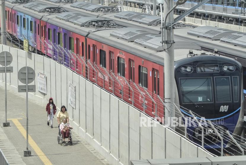 Sejumlah pejalan kaki melintas di samping kereta MRT (Mass Rapid Transit)  stasiun Lebak Bulus, Jakarta Selatan, Senin (13/5).