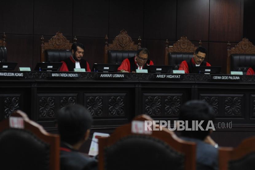 Ketua Majelis Hakim Mahkamah Konstitusi (MK) Arief Hidayat (tengah) bersama Hakim MK Anwar Usman (kiri) dan I Dewa Gede Palguna (kanan) membacakan putusan sepuluh perkara PUU, di ruang sidang gedung MK, Jakarta, Selasa (12/12).