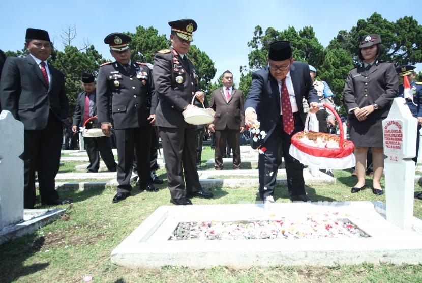 Gubernur Jawa Barat Ahmad Heryawan menaburkan bunga usaia upacara peringatan Hari pahlawan di Taman makam Pahlawan Cikutra, Kota Bandung, Kamis (10/11).