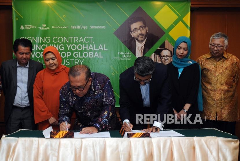 Chairman Indonesia Halal Lifestyle Center (IHLC) Sapta Nirwandar (ketiga kiri) dan CEO Dinar Standard Rafi'uddin Shikoh (keempat kiri) menandatangani kontrak kerjasama usai diskusi Workshop Global Halal Industry di Grand Sahid Jaya, Jakarta, Kamis (3/5).