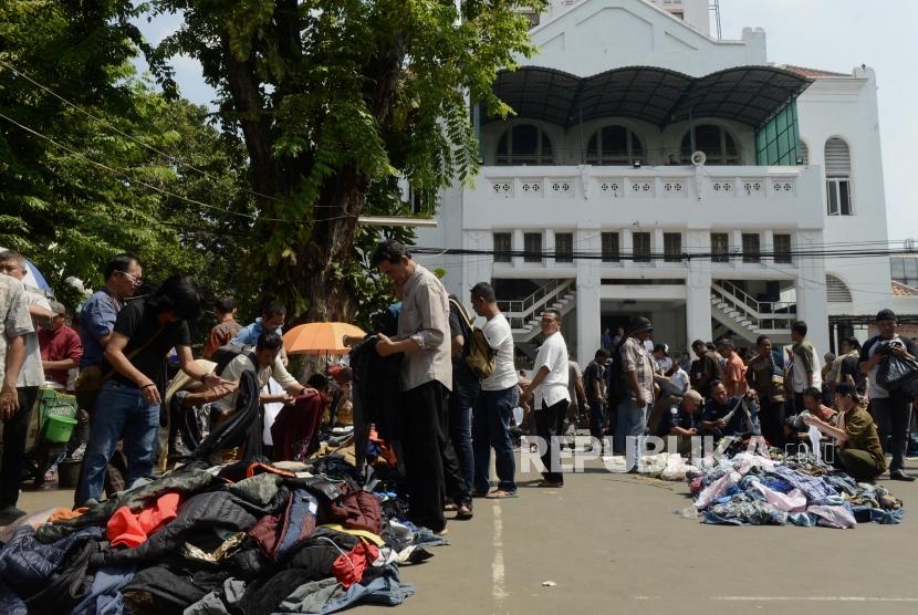 Sejumlah pedagang menggelar barang daganganya usai Shalat Jumat di halaman Masjid Cut Meutia, Jakarta, Jumat (26/7).