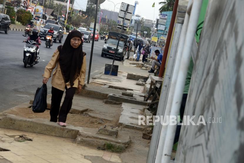 Pejalan kaki melintasi trotoar di Jalan Margonda Raya, Depok, Jawa Barat. Kepemimpinan Wali Kota Depok Muhammad Idris dinilai tak memajukan Kota Depok. Ilustrasi.