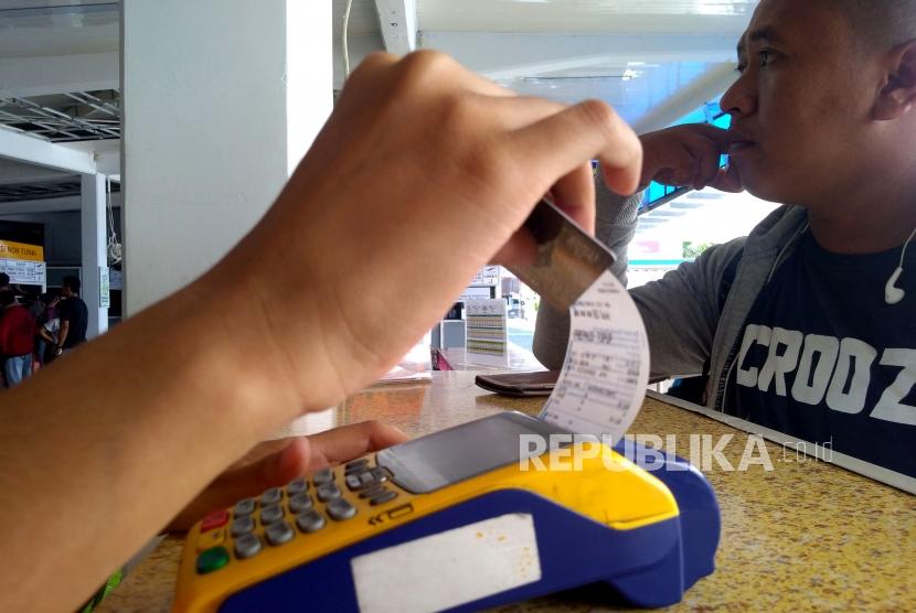 Penumpang melakukan isi ulang (top-up) uang elektronik untuk membeli tiket kapal di Pelabuhan Merak, Banten, Jumat, (3/5).