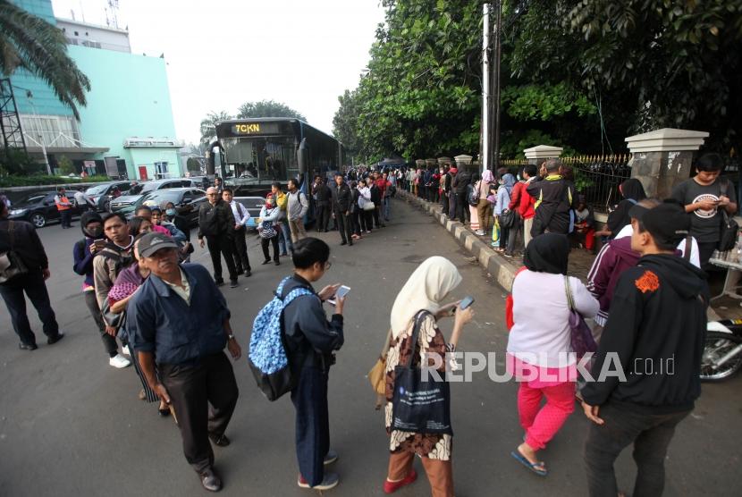 Sejumlah warga mengantre di Halte Transjakarta kawasan Cibubur, Jakarta Timur, Senin (16/4).