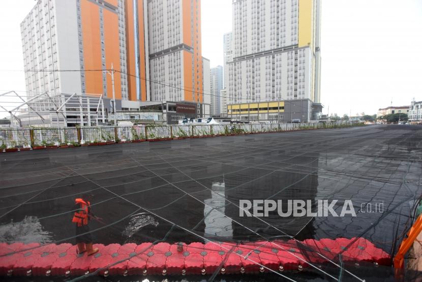 Petugas PPSU memberihkan sampah di Kali Sentiong yang sudah dipasang jaring (waring) di Kawasan Kemayoran, Jakarta, Jumat (20/7).