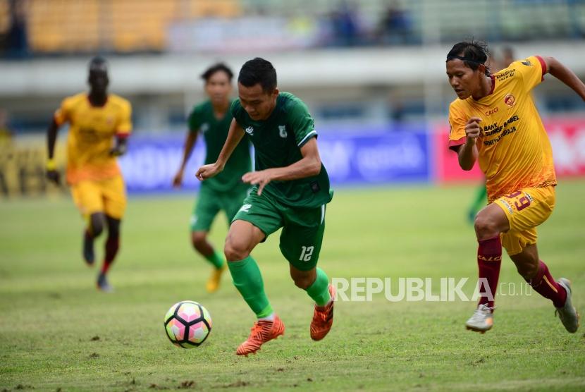 Gelandang PSMS Medan Erwin Ramdani menggiring bola dibayangi Adam Alis (kanan) dalam pertandingan Grup A Piala Presiden 2018 di Stadion GBLA Bandung, Jumat (26/1).