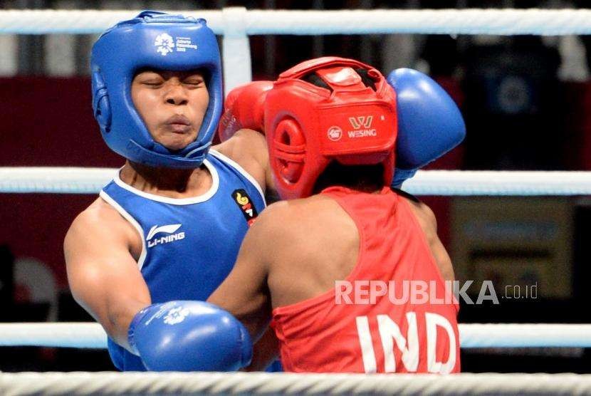 Petinju Indonesia Huswatun Hasanah (biru) saat berlaga dengan petinju petinju India Pavita dalam pertandingan perempat final cabang Tinju Kelas ringan putri 57-60 Kg Asian Games 2018 di Hall Jakarta International Expo, Kemayoran, Jakarta, Selasa (28/8).