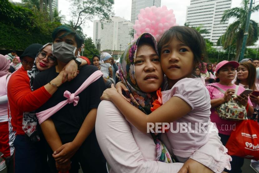 Sejumlah ibu-ibu yang tergabung dalam Komunitas perempuan Keren memeluk anaknya saat acara Peluk Ibu Satu Indonesia di Bundaran HI, Jakarta, Ahad (23/12).