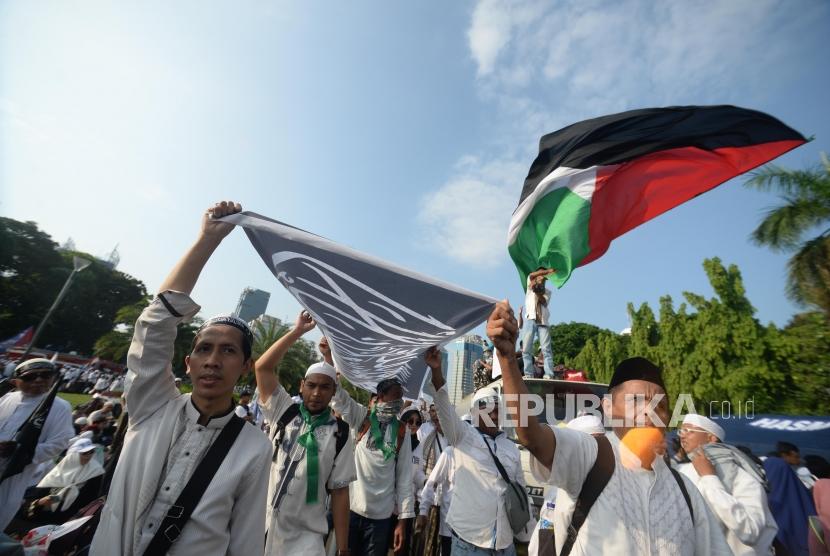 masa  reuni aksi 212 membawa spanduk tauhid dan bendera palestina saat  reuni aksi 212  di Lapangan Monumen Nasional, Jakarta, Ahad, (2/12).