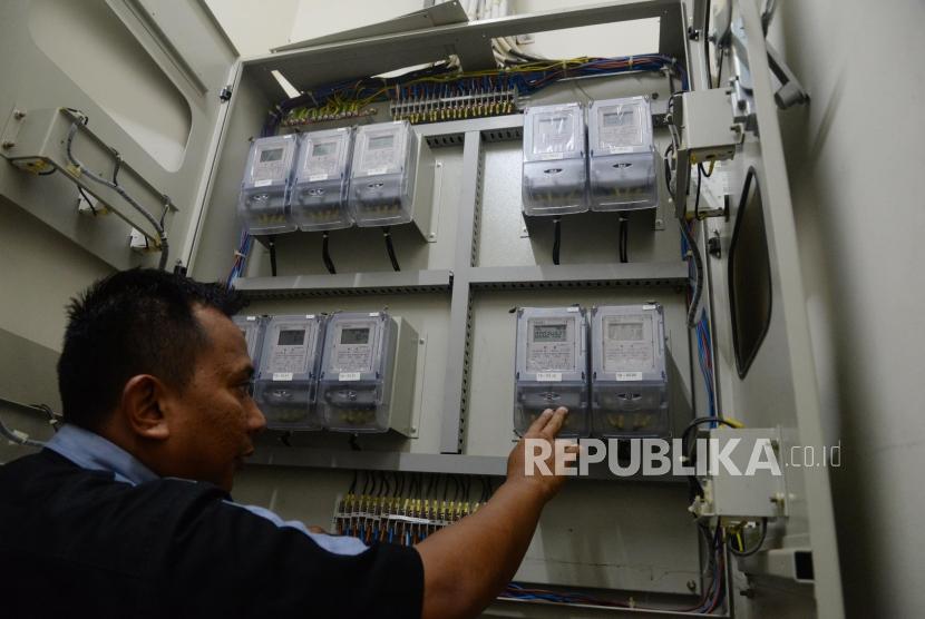 Petugas memeriksa meteran listrik di Rumah Susun Jatinegara Barat, Jakarta, Senin (13/11).
