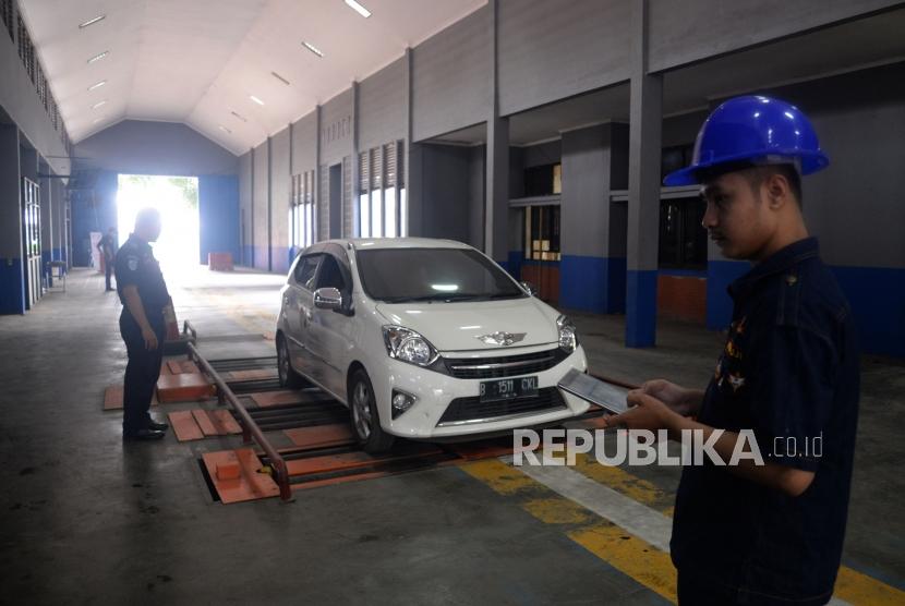 Petugas melakukan aktivitas uji kir gratis pada kendaraan di Unit Pelayanan Teknis Daerah Pengujian Kendaraan Bermotor (UPTD PKB) Dinas Perhubungan Kota Tangerang, Banten, Selasa (6/3).