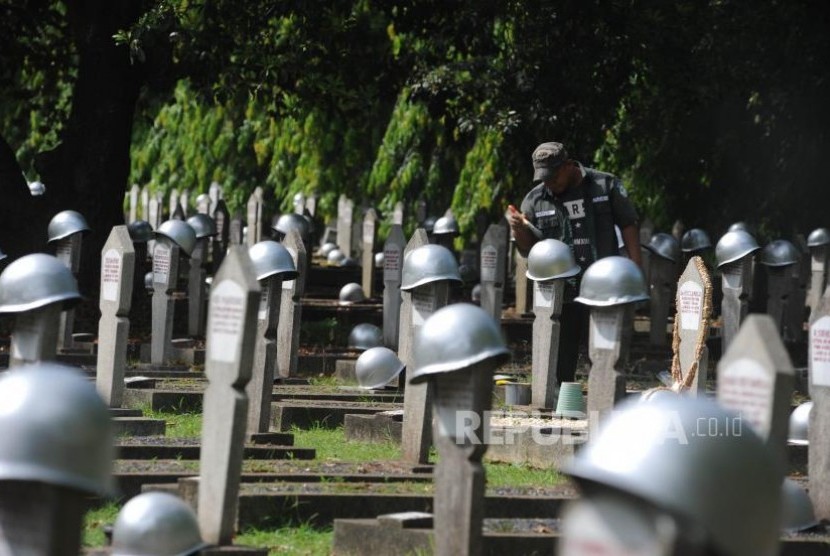 Mengecat. Petugas TMP Kalibata mengecat helm di TMP Kalibata, Jakarta, Rabu (8/11). Menjelang peringatan hari pahlawan TMP Kalibata melakukan persiapan seperti mengecat dan menambah bunga di setiap makam yang berada di TMP Kalibata.