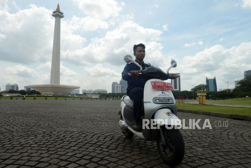 Petugas mengendarai motor listrik di Monumen Nasional, Jakarta, Jumat (14/12).