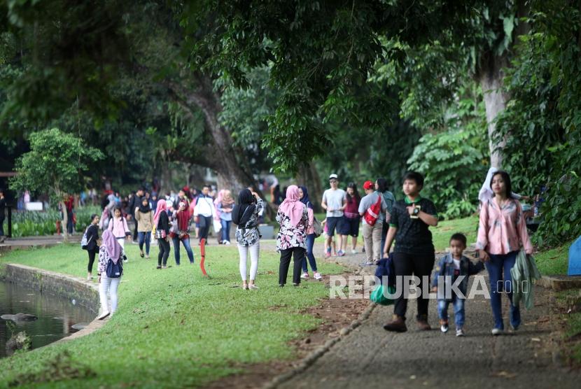 Warga berwisata ke Kebun Raya Bogor, Jawa Barat, Sabtu (23/12).
