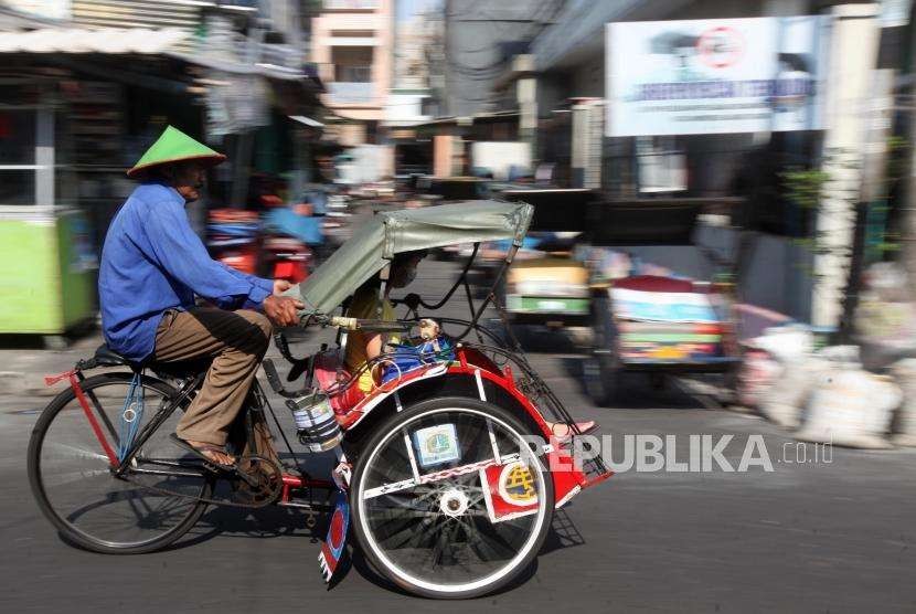 Penarik becak mengayuh becaknya saat mengantarkan penumpang di kawasan Teluk Gong, Pejagalan, Jakarta, Kamis (11/10).