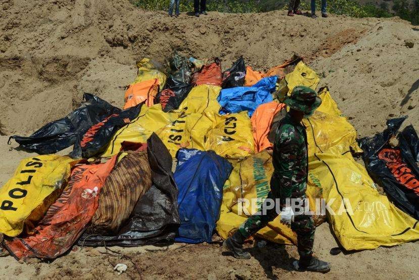 Sejumlah Prajurit TNI melakukan penguburan massal terhadap jenazah korban gempa bumi dan tsunami di Taman Pemakaman Umum (TPU) Poboya Indah, Palu, Sulawesi Tengah, Selasa (2/10).