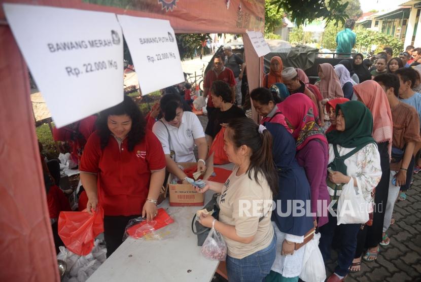 Sejumlah warga mengantri untuk membeli bawang putih dan bawang merah ketika gelar pangan murah berkualitas di Toko Tani Indonesia Center, Jakarta, Ahad (5/5).