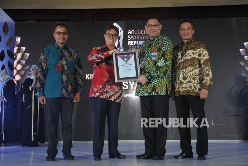   Ketua LPS Fauzi Ikhsan (kedua kiri) memberikan kepada perwakilan pemenang Bank Syariah Kinerja dan Inovasi Terbaik Aset 30 Triliun keatas kepada BNI Syariah dalam Anugerah Syariah Republika (ASR) 2017 di Jakarta, Rabu (6/12)malam. 