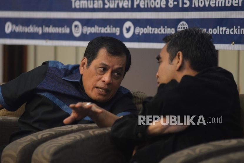 Ketua Harian Partai Golkar Nurdin Halid (kiri) berbincang bersama Sekjen Partai Gerindra Ahmad Muzani (kanan) disela diskusi hasil Survei Nasional poltracking Indonesia terkait Pemerintahan Jokowi-JK di Jakarta, Ahad (26/11).
