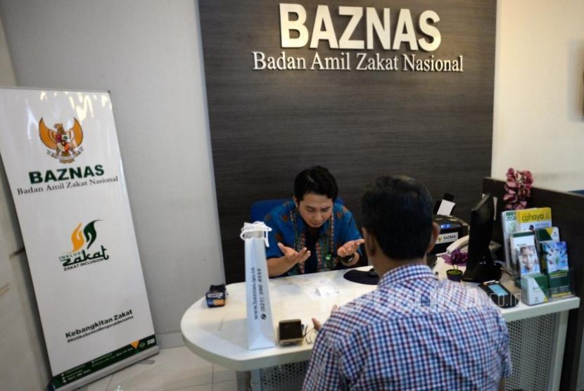 Muzaki membayarkan zakat dengan petugas di kantor palayanan Baznas, Jakarta, Kamis (2/11).