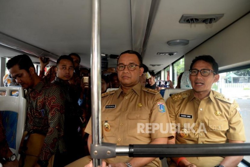 Gubernur DKI Jakarta Anies Baswedan dan Wakil Gubernur Sandiaga Uno menaiki bus City Tour di Halte Dukuh Atas, Jakarta, Selasa (17/10).