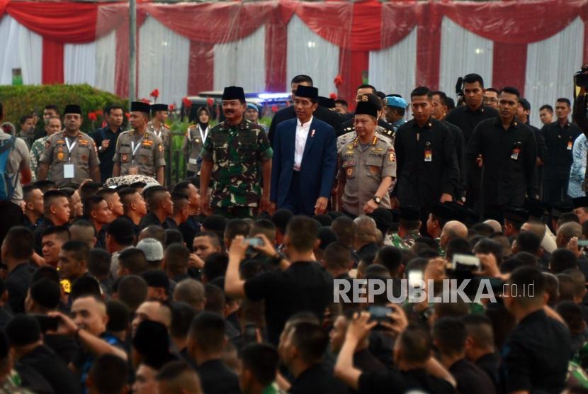 Presiden Joko Widodo bersama Panglima TNI Marsekal Hadi Tjahjanto dan Kapolri Jenderal Tito Karnavian saat menghadiri acara buka bersama TNI-Polri di Lapangan Monas, Jakarta, Kamis (16/5).