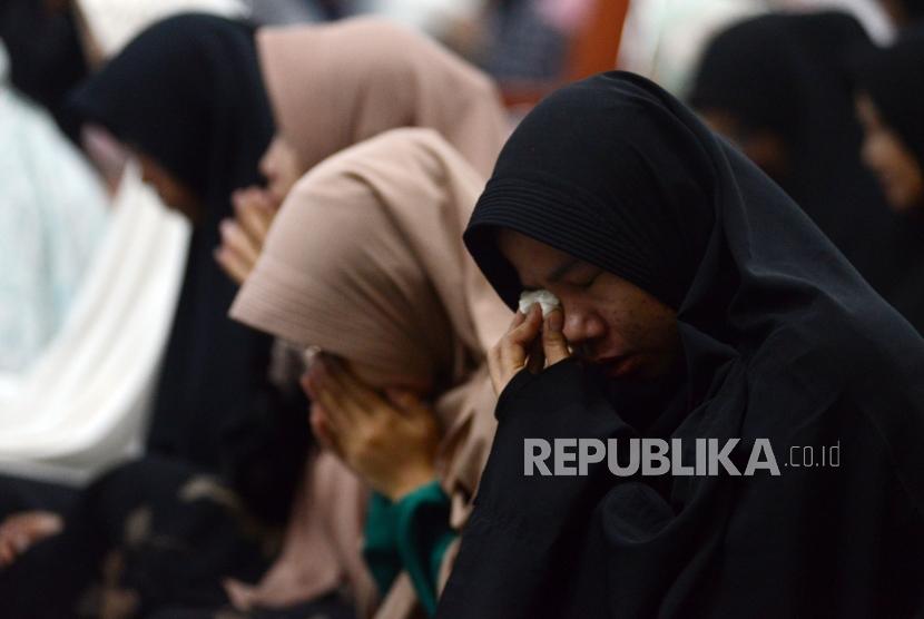 Sejumlah umat Islam menangis saat acara Dzikir Nasional di Masjid Agung At Tin, Jakarta, Senin (31/12).
