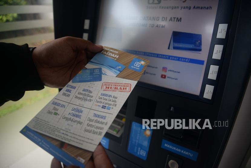 Nasabah membaca brosur usai melakukan transaksi melalui ATM BRI Syariah di Jakarta, Ahad (4/3).