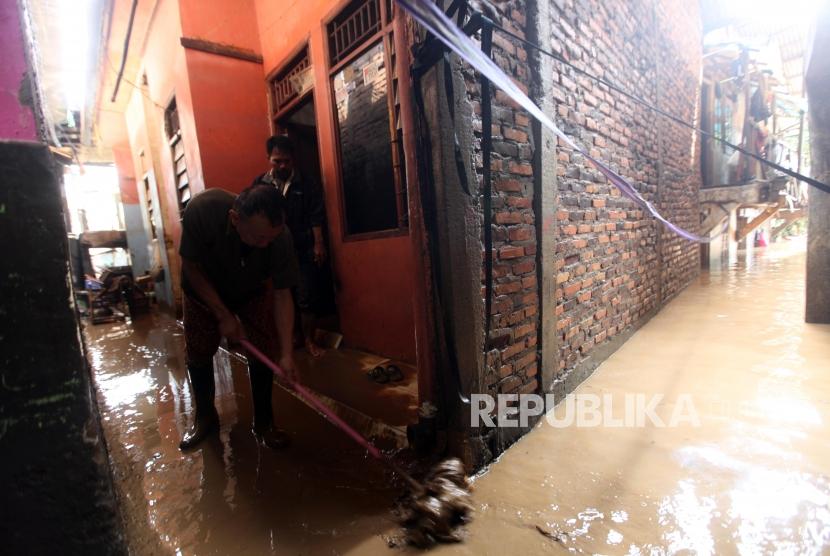 Warga membersihkan rumahnya dari lumpur pasca banjir di Kawasan Rawajati, Jakarta, Selasa (6/2).