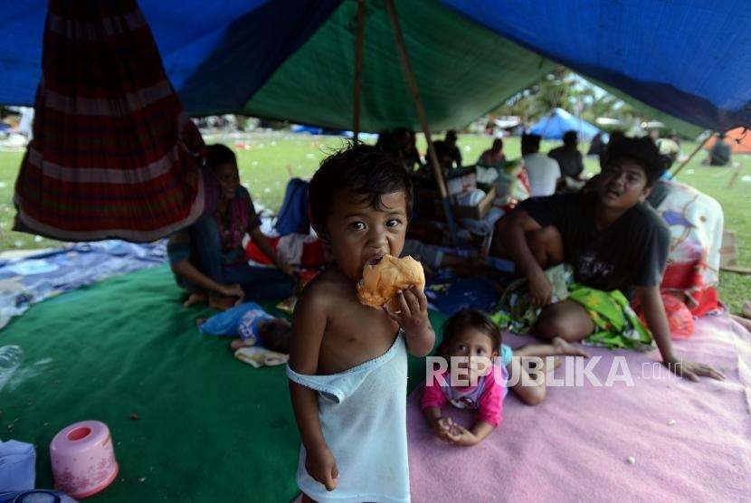 nak-anak memakan roti di tenda pengungsian di Lapangan Vatulemo, Palu, Sulawesi Tengah.