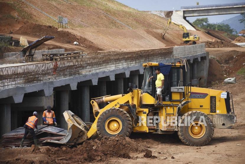 Pekerja menggunakan alat berat menyelesaikan pembangunan Jalan Tol Cileunyi-Sumedang-Dawuan (Cisumdawu) di Kabupaten Sumedang, Sabtu (1/6).