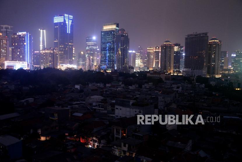 Suasana ketika terjadinya pemadaman listik di kawasan pemukiman padat penduduk Karet Tengsin, Jakarta, Ahad (4/8).