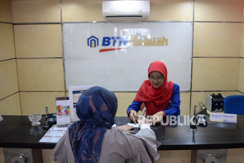 Petugas melayani transaksi nasabah di kantor layanan BTN Syariah, Jakarta, Senin (1/10). PT Bank Tabungan Negara (Persero) Tbk belum memutuskan langkah aksi pemisahan Unit Usaha Syariah (UUS) pada 2023 mendatang. 