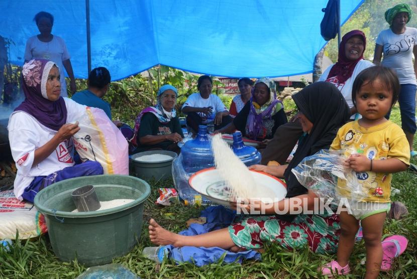 Ibu-ibu menampi beras yang akan di masak di dapur umum Posko Kemanusiaan ACT, di desa Lompio, Kabupaten Sirenja, Donggala Sulawesi Tengah, Ahad (14/10).