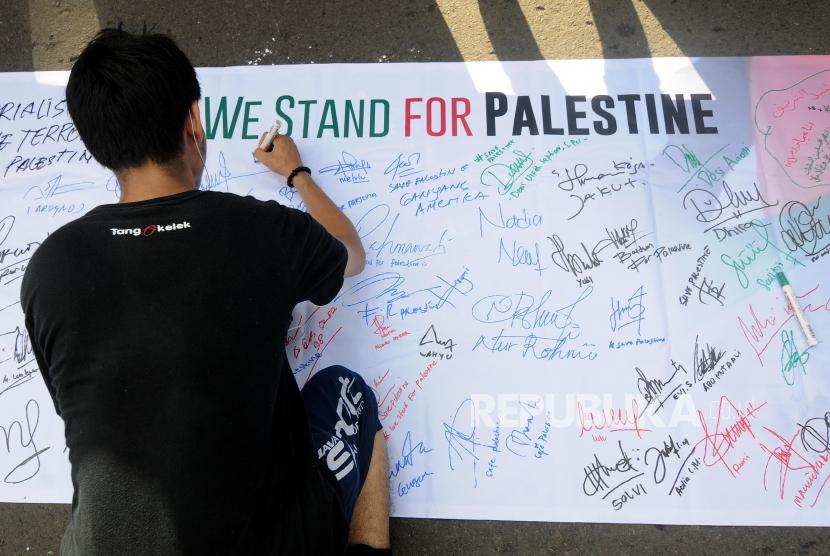 Aksi Bela Palestina. Warga melakukan tanda tangan pada aksi bela Palestina yang diusung oleh Masyarakat Relawan Indonesia (MRI) dan Aksi Cepat Tanggap (ACT) di Bundaran Hotel Indonesia (HI), Jakarta Pusat, Ahad (10/12).