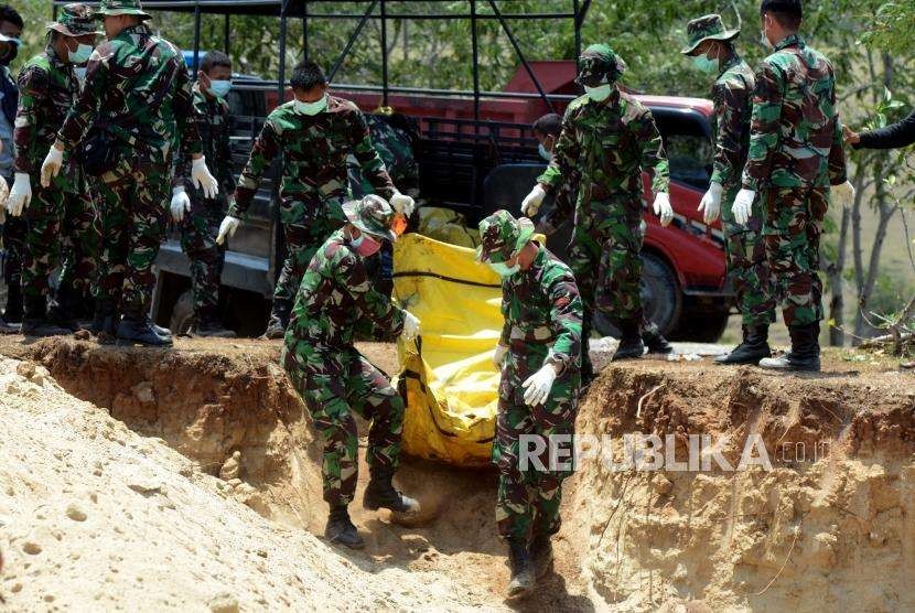 Sejumlah Prajurit TNI melakukan penguburan massal terhadap jenazah korban gempa bumi dan tsunami di Taman Pemakaman Umum (TPU) Poboya Indah, Palu, Sulawesi Tengah, Selasa (2/10).