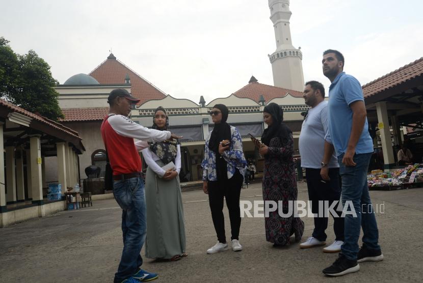 Pemandu wisata memberikan informasi kepada peserta Muslim Exchange Program (MEP) saat berkunjung ke Masjid Luar Batang, Jakarta, Jumat (16/3).
