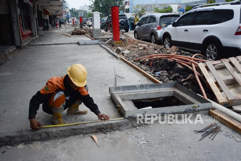Pekerja menyelesaikan pembuatan trotoar di kawasan Cikini, Jakarta.